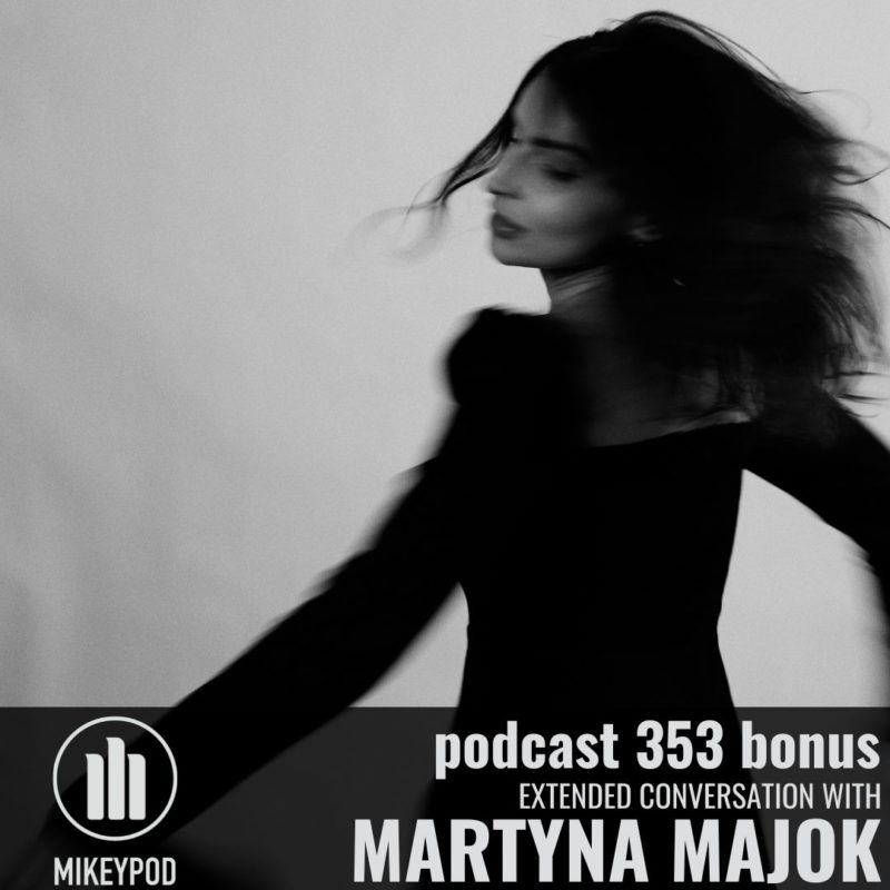 Black and white photograph of Martina who appears to be twirling in the photo. Her long dark hair is swooshing around as she twirls and she is wearing a black dress.